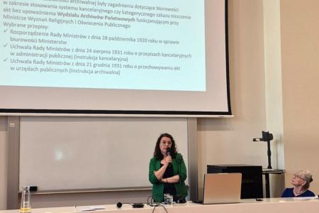 Anna Jastrzębska-Pawlak w czasie wystąpienia; za stołem prezydialnym również Wanda K. Roman